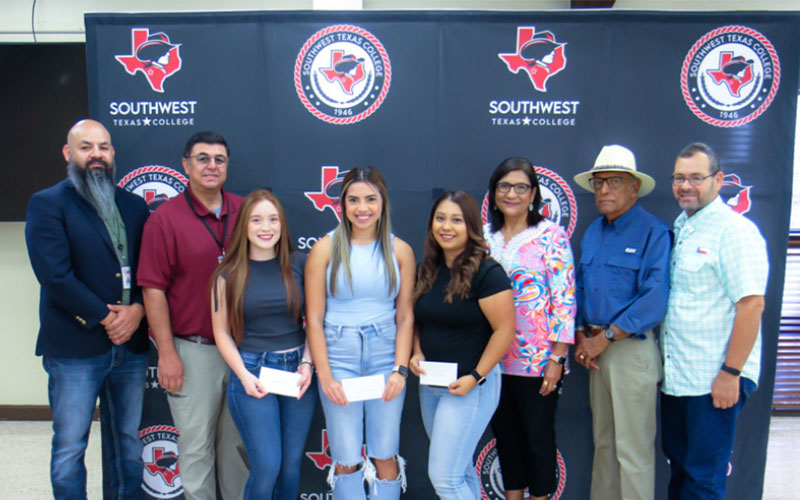 Moreno family poses with scholarship recipients and Vice President of Student Services Cruz Mata and President Hector Gonzales.